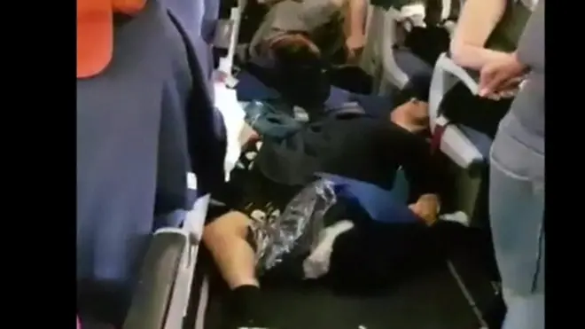 ผู้โดยสารนอนบนช่องทางเดินเครื่องบิน