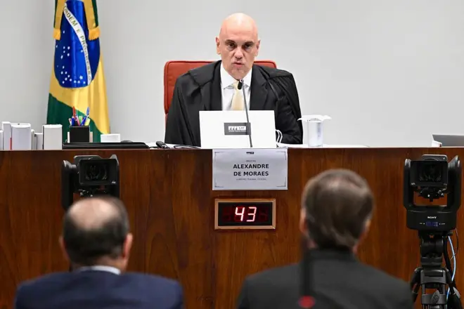 O ex-presidente brasileiro Jair Bolsonaro (R), sentado ao lado de seu advogado Celso Villardi (L), depõe perante o juiz Alexandre de Moraes durante uma sessão de julgamento do Supremo Tribunal Federal que julga a participação dos acusados da tentativa de golpe de Estado em janeiro de 2023, em Brasília, 10 de junho de 2025.