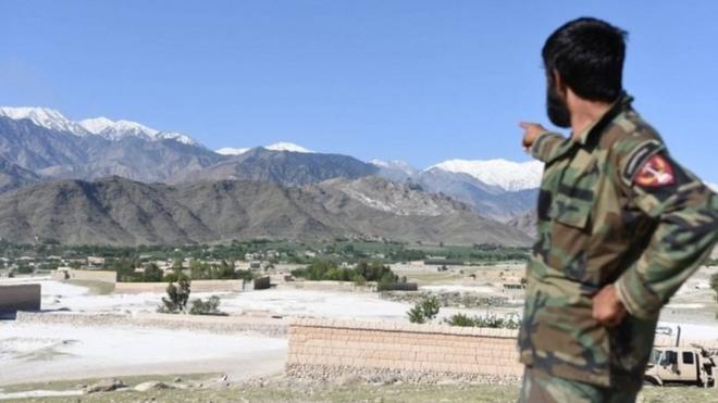 阿富汗一士兵指著山谷中炸彈之母落下的地方