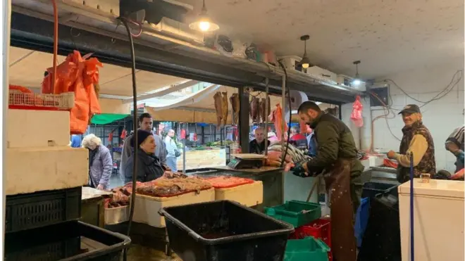 prodavac čisti ribu na zemunskoj pijaci