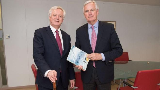 David Davis and Michel Barnier holding each other's gifts