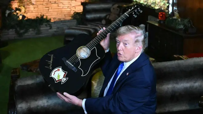US President Donald Trump holds up a guitar on a visit to Graceland in Memphis, Tennessee, USA.