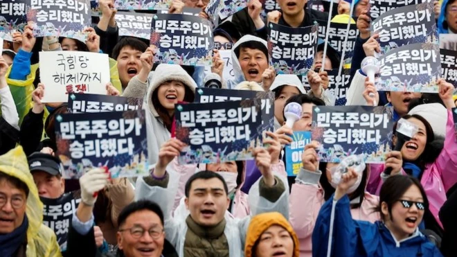 '민주주의가 승리했다' 슬로건을 흔드는 집회 참가자들