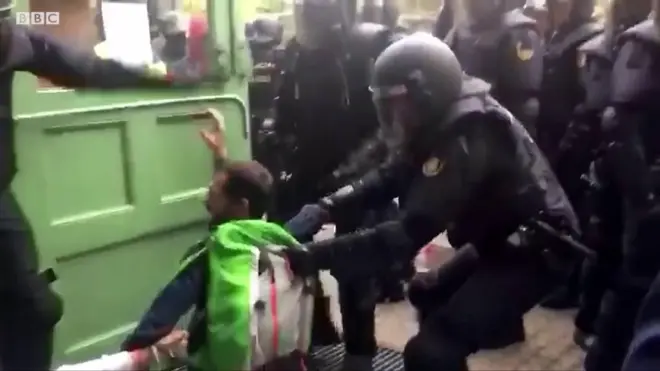 Полицейские вытаскивают людей с избирательных участков.