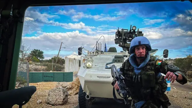 A UN peacekeeper gets into an armoured vehicle