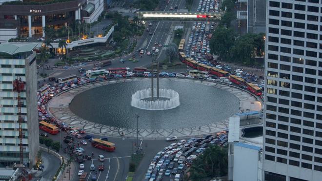 Dòng xe cộ lưu thông qua các tòa nhà cao tầng ở trung tâm Jakarta