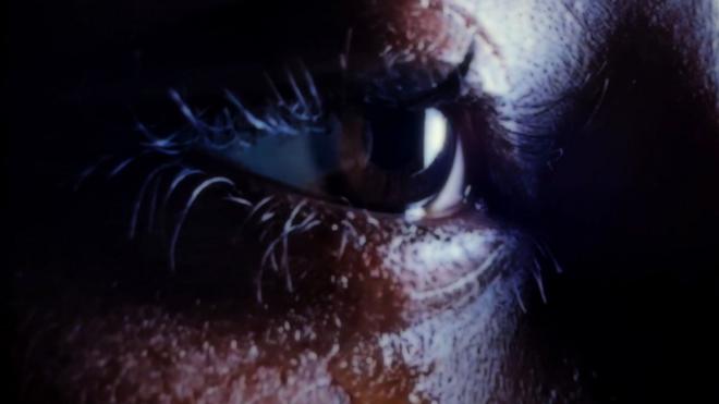 Close up picture of woman's eye with a tear drop falling on her lower eyelid.