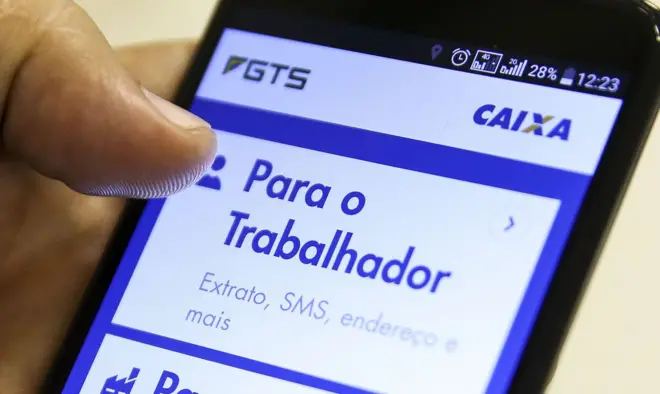 Mão segurando celular aberta na página do FGTS no aplicativo da Caixa