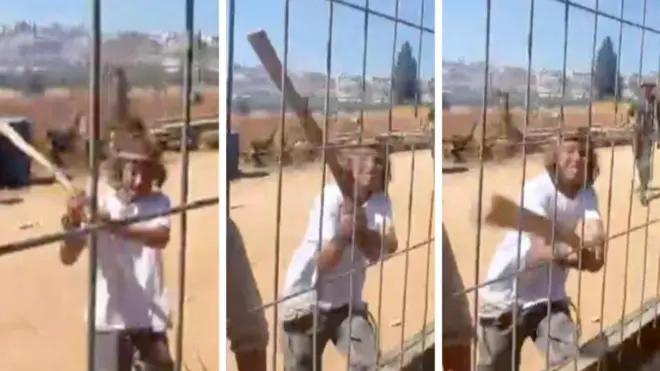 Joven ataca una reja en medio de Cisjordania con un palo