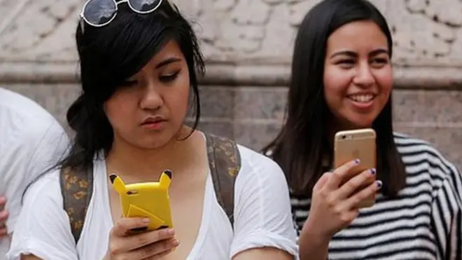 मोबाईल हाती घेतलेले लोक.