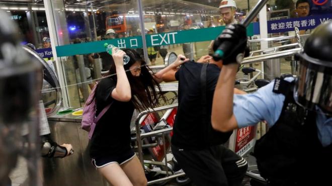 Riot police use pepper spray to disperse anti-extradition bill protesters during a mass demonstration after a woman was shot in the eye, at the Hong Kong international airport