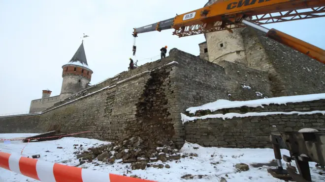 Будівельники розбирають частину муру поблизу місця обвалу