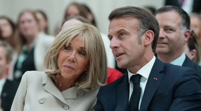 Brigitte e Emmanuel Macron fotografados em um evento público em Londres no início de julho, sentados um ao lado do outro