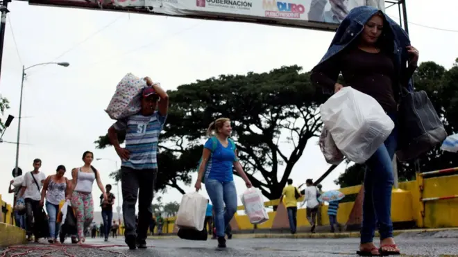 Венесуэльцы несли с собой мешки с продуктами и товарами первой необходимости