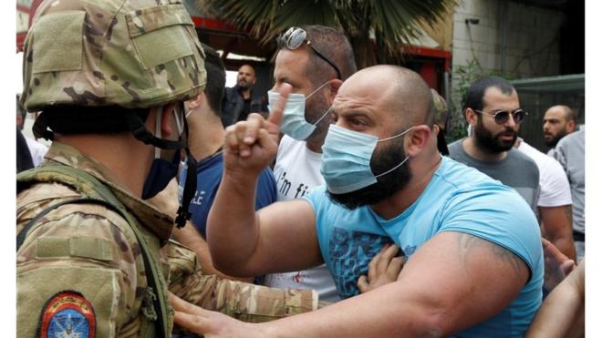 صورة أرشيفية لمتظاهر لبناني يواجه عسكريا