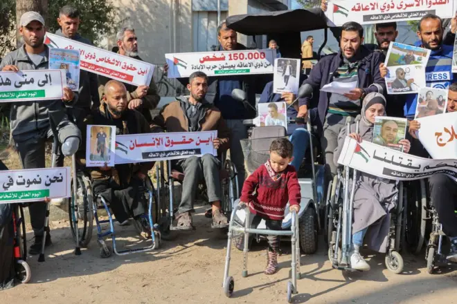 مجموعة ممن أصيبوا بإعاقات بفعل الحرب في غزة تجمعوا خارج المستشفى الأهلي العربي بالقطاع إحياء لليوم العالمي لذوي الإعاقة