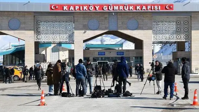 عکسی از گذرگاه مرزی رازی (کاپیکوی) در وان. جلوی گمرک خبرنگاران و تجهیزاتشان دیده میشوند و در پسزمینه چند نفر در حال راه رفتن هستند.