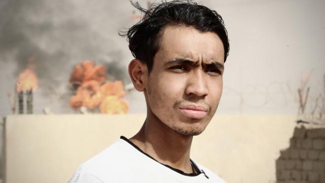 Ali Hussein Julood, joven de 19 años de Rumaila, frente a una quema de gas.