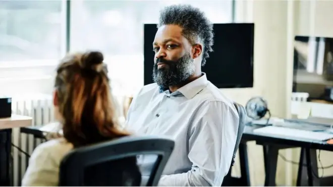 Male colleague looks at a female colleague