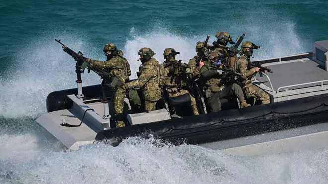 NATO Özel Operasyon Kuvvetleri subayları, 18 Mayıs 2026 tarihinde Romanya'nın güneydoğusundaki Köstence'de denizde düzenlenen Trojan Footprint 2026 (TFP26) askeri tatbikatı sırasında görülüyor. TFP26, Avrupa'da ABD Özel Operasyon Kuvvetleri (SOF) liderliğinde gerçekleştirilen en büyük tatbikat olup, yaklaşık 1.000 ABD askeri personeli ile NATO'nun 23 müttefik ve ortak ülkesinden 2.000 SOF personelini bir araya getiriyor. Mayıs ortasına kadar süren tatbikat, Yunanistan ve Gürcistan dahil olmak üzere çok sayıda Doğu Avrupa ülkesini kapsıyor ve kara ve deniz operasyonlarını içeriyor. 