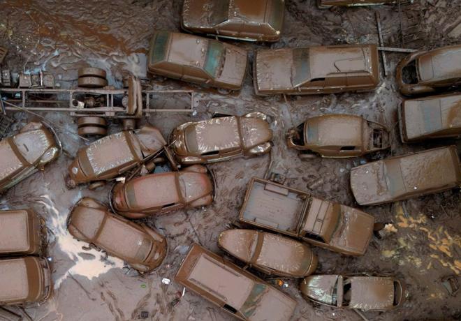 Foto aerea mostra carros cobertos por lama na rua