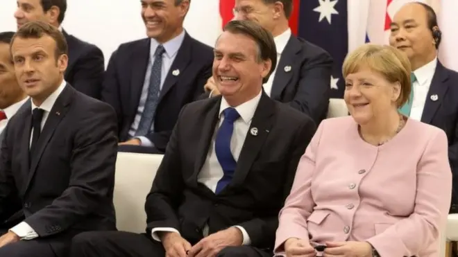 Bolsonaro (centro) com Emmanuel Macron (esq.) e Angela Merkel (dir) no Japão: presidente perderia a aposta a respeito da Amazônia