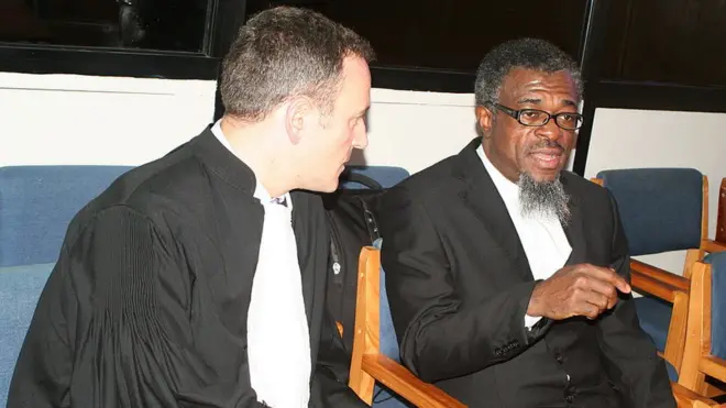 Capt Sagahutu (iburyo) wari wungirije umukuru w'umutwe w'ingabo zikora ubutasi (bataillon de reconnaissance), aha yaganiraga n'umwunganizi we i Arusha mbere y'ubujurire, bwagabanyije igifungo cye kikava ku myaka 20 kigashyirwa kuri 15