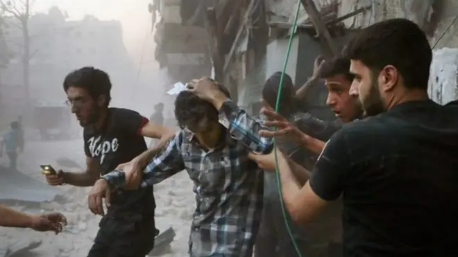 Syrians help an injured man, (centre) after airstrikes hit Aleppo, Syria (31 July 2016)