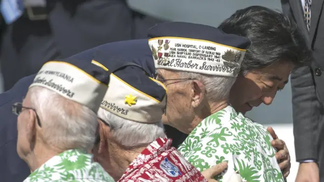 Perdana Menteri Jepang, Shinzo Abe, menyapa dan memeluk para korban selamat peristiwa serangan Pearl Harbor.