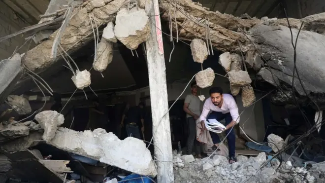 فلسطيني وسط ركام أحد المنازل المدمرة في غزة