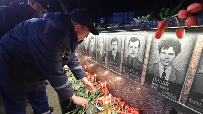 Firefighters leave flowers at a Chernobyl memorial in northern Ukraine (2018)