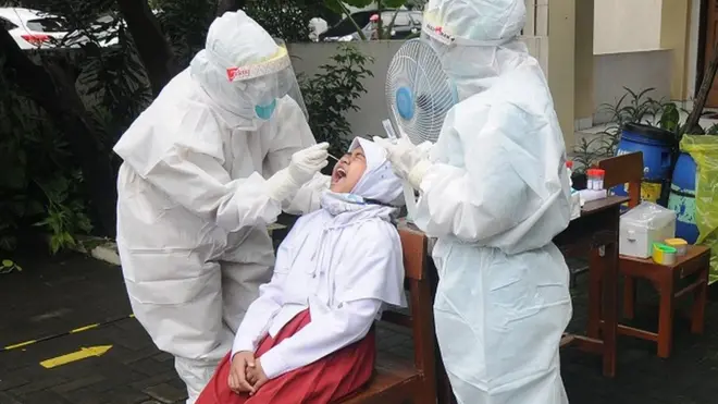 Petugas kesehatan mengambil sampel tes usap PCR pelajar di SD Negeri Kestalan 5, Solo, Jawa Tengah, Selasa (23/11).