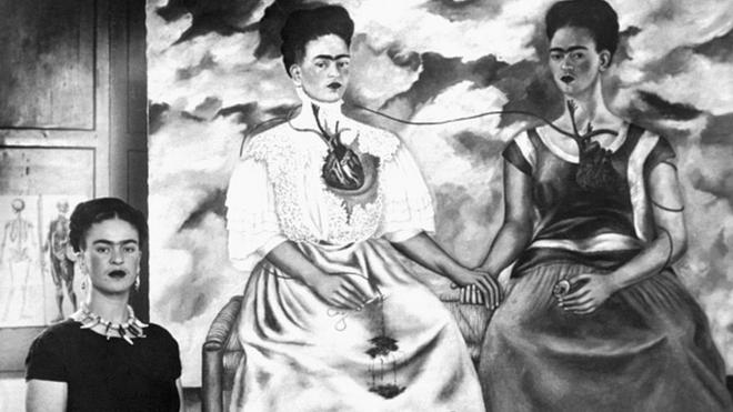 Frida Kahlo frente a uno de sus autorretratos.
