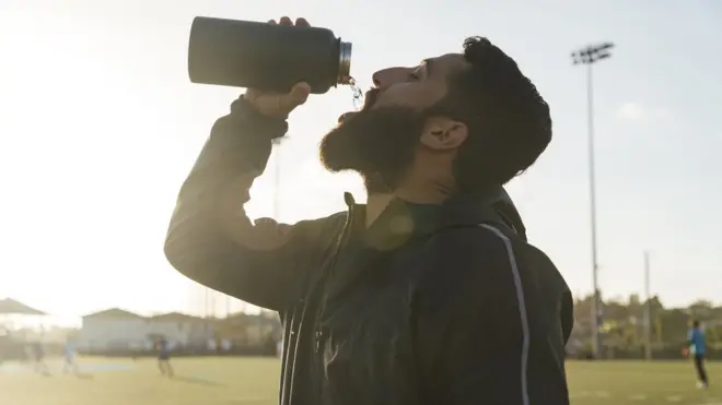 شاب رياضي يشرب الماء