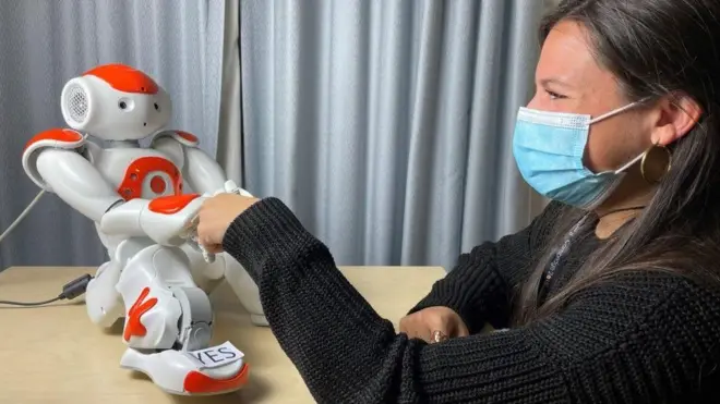 روبوت صغير يتفاعل مع سيدة.