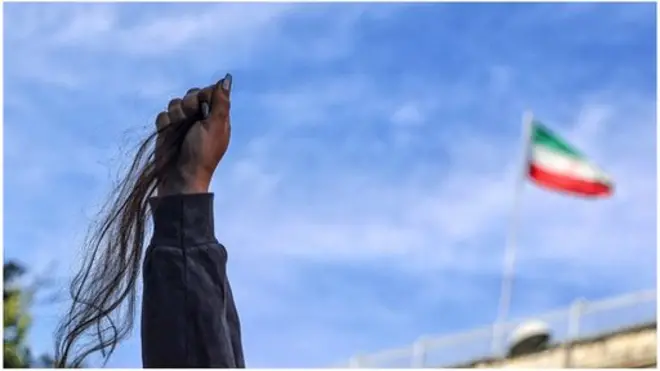 امرأة تحمل شعرها كأنه علم