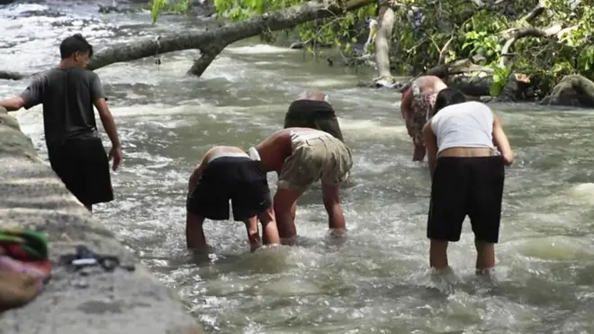 Jóvenes buscando metal en el río Guaire de Caracas
