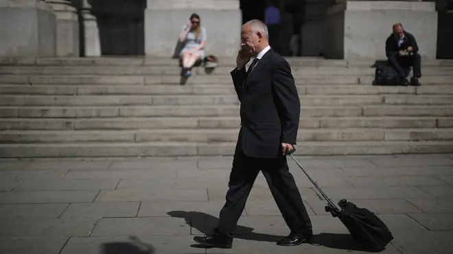 Работник Сити с чемоданом и мобильным