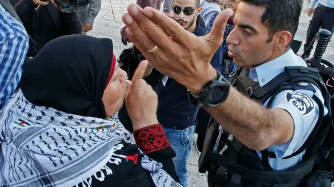 امرأة فلسطينية تصرخ في رجل أمن إسرائيلي أثناء مظاهرات في القدس عند باب دمشق، مناوئة لنقل السفارة الأمريكية للقدس، يوم 15 مايو/أيار 2018