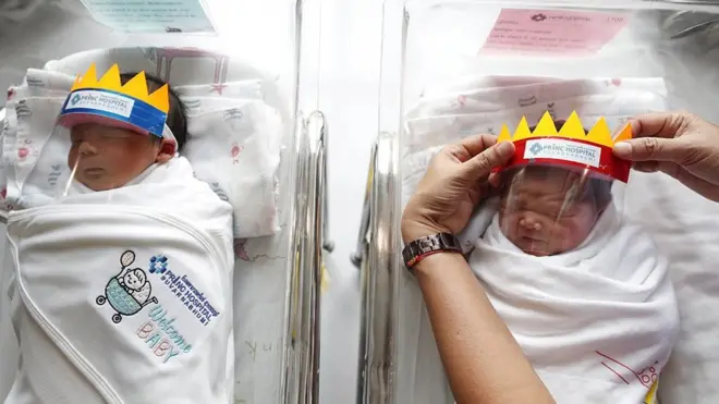 A nurse puts face shields on newborn babies as a precaution against the coronavirus pandemic at Prince Hospital Suvarnabhumi, Thailand.
