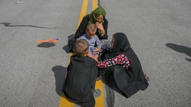 카불을 떠나기 위해 공항 활주로에 앉아 있는 아프간 여성과 아이들