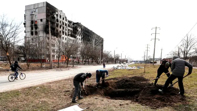 Digging graves by the roadside in Mariupol, 20 March