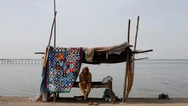 A flood victim takes refuge along a road in a makeshift tent, following rains and floods during the monsoon season in Mehar, Pakistan August 29, 2022.