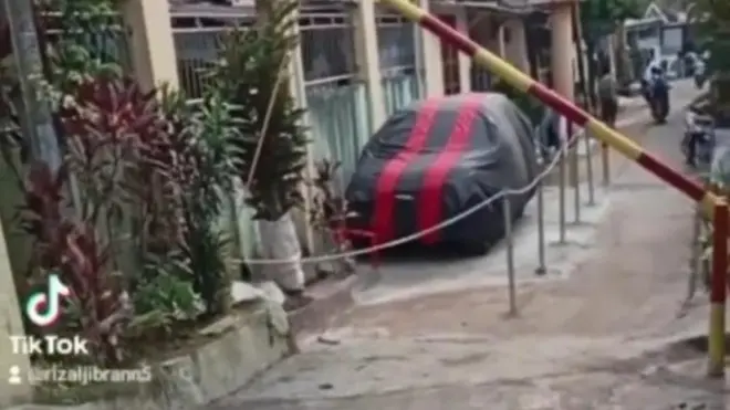 Penampakan garasi mobil yang menggunakan sebagian jalan umum baru-baru ini di Bekasi, Jawa Barat, ramai diperbincangkan warganet.