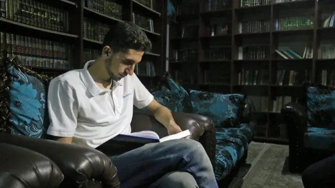 Abdulbaset Alahmar, fanático de Hamlet, es uno de los visitantes de la biblioteca que funciona en un sótano.