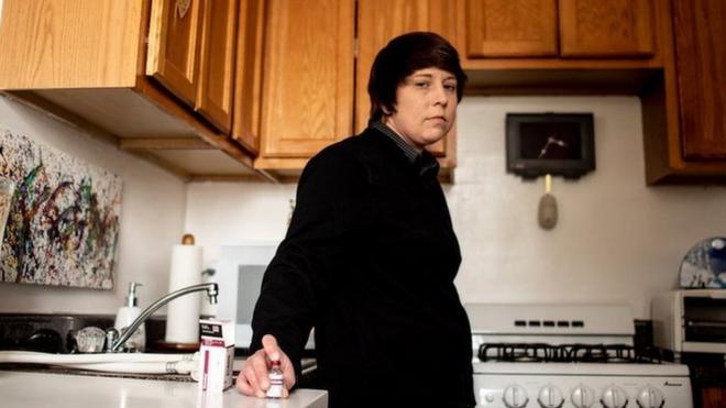 Laura Marston stands in her kitchen, where she stores insulin in a quarter of her fridge