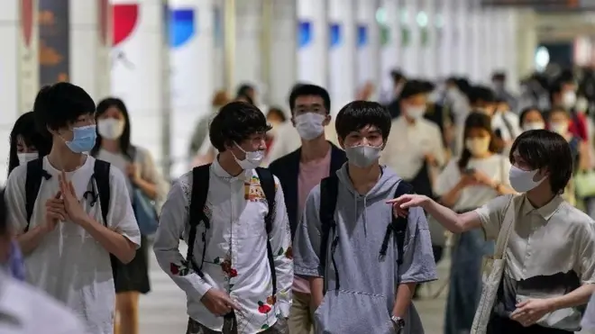 मास्क लगाकर चलते लोग