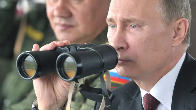 Russian President Vladimir Putin (R) and Defence minister Sergei Shoigu (L) inspect military exercises in the Pacific Ocean near the Sakhalin island on July 16, 2013
