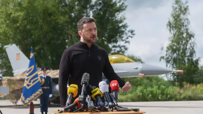 O presidente da Ucrânia, Voldymyr Zelensky, discursandoaplicativo bingo paga mesmofrente a um dos caças F-16 que a Ucrânia recebeuaplicativo bingo paga mesmojulho.