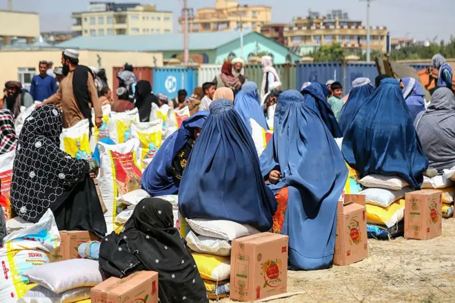 شماری از زنان در محل دریافت کمک نشسته اند